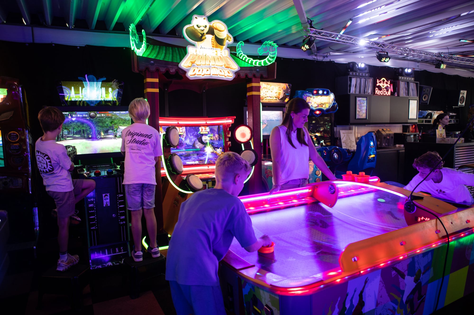 Bezoekers spelen airhockey tussen de arcadekasten in de gamehal. 