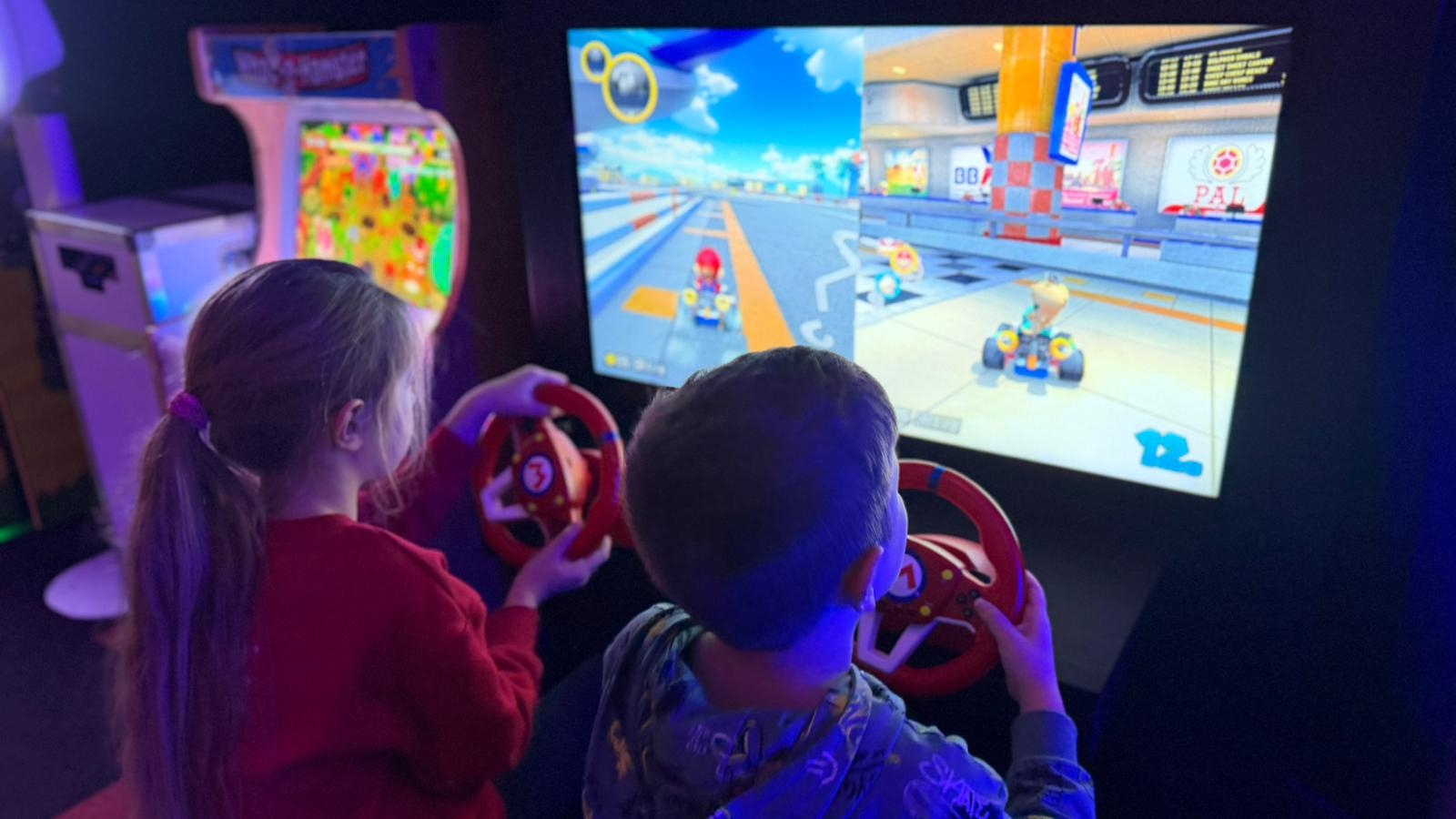 kinderen spelen mario kart in de gamehal