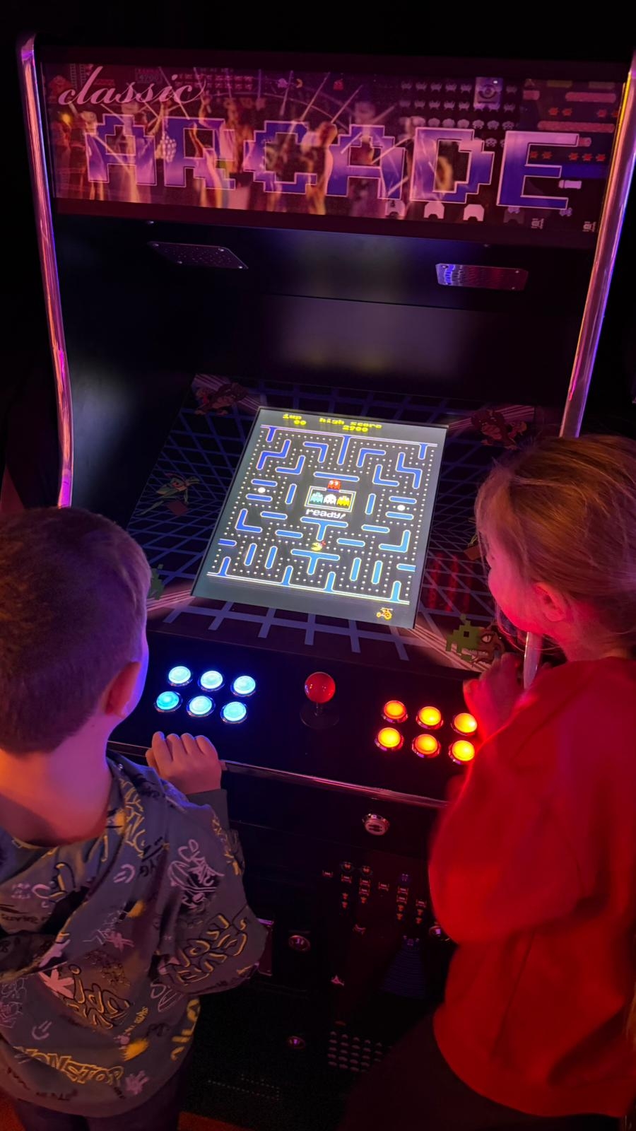 kinderen spelen pacman in de arcadehal