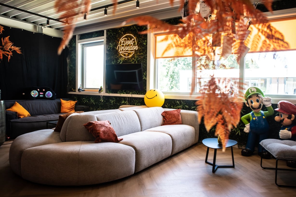 Lounge met zithoeken, statafels en sfeervolle verlichting in GameLounge Leusden