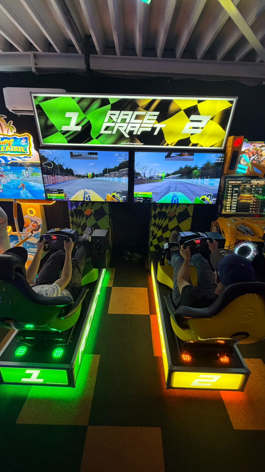 Twee bezoekers racen naast elkaar op de Race Craft racesimulatoren in de arcadehal in Leusden.
