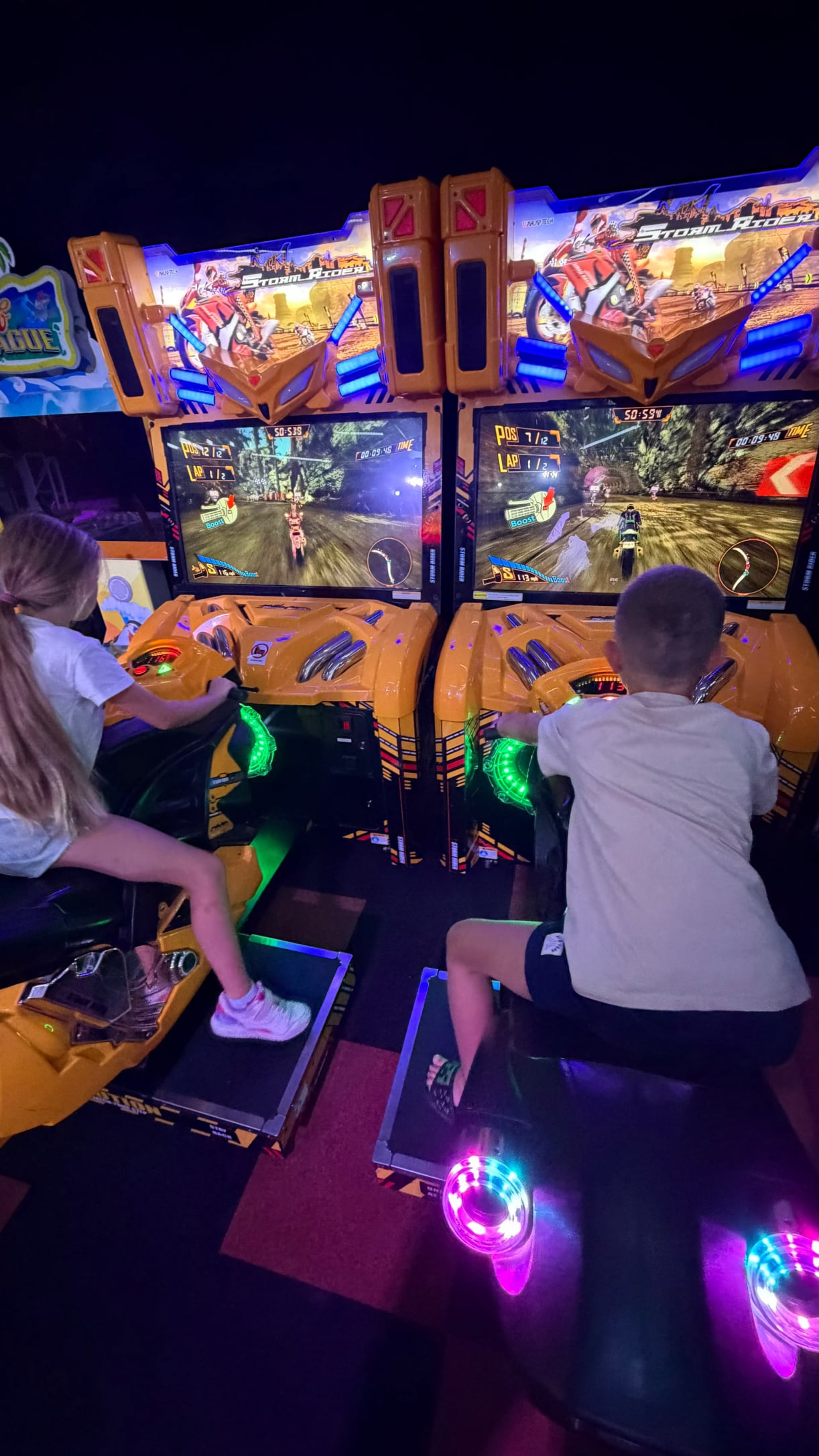Twee kinderen spelen op de Storm Rider motorsimulatoren bij Game Lounge Leusden.